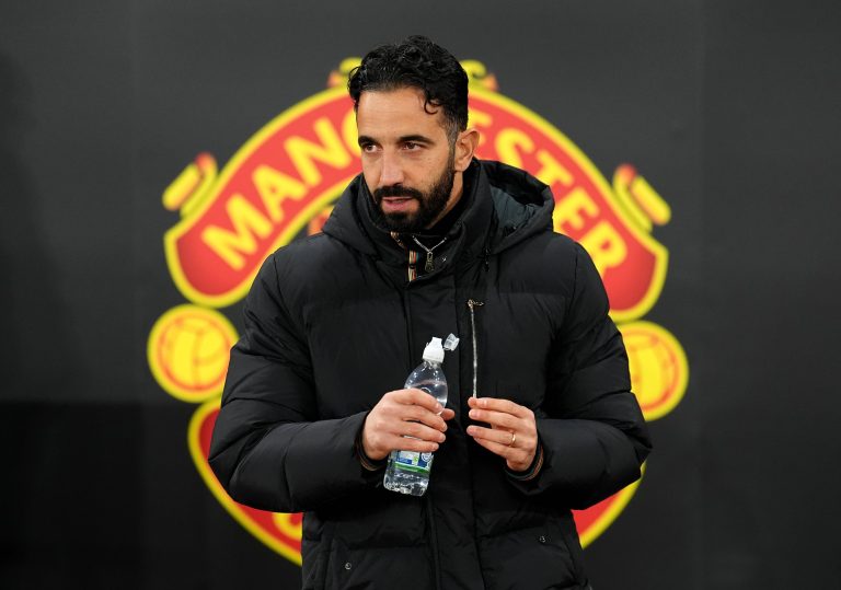 Ruben Amorim in front of Manchester United crest